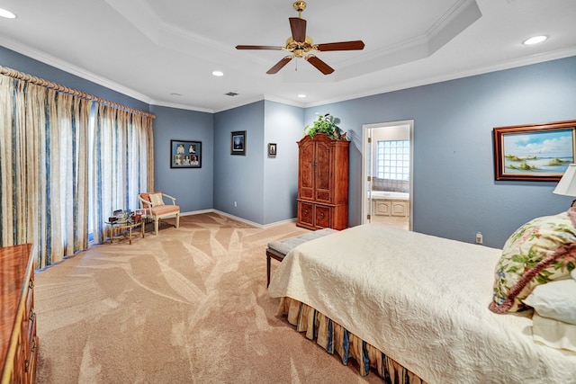 carpeted bedroom featuring crown molding, connected bathroom, a tray ceiling, and ceiling fan