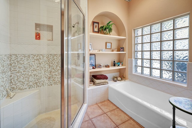 bathroom with built in shelves, tile patterned floors, and shower with separate bathtub