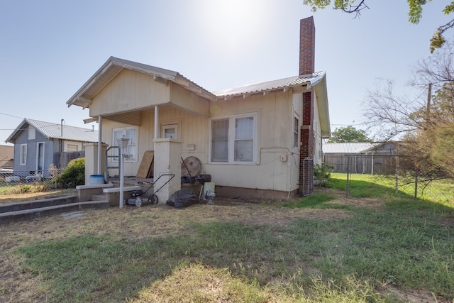 rear view of property featuring a lawn