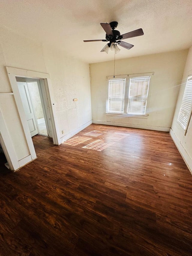 empty room featuring ceiling fan, dark hardwood / wood-style flooring, and a textured ceiling