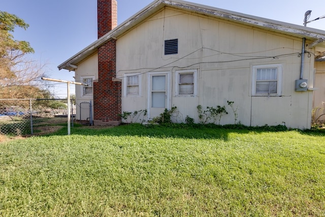 rear view of property with a lawn