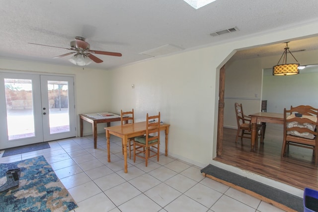 dining room featuring ceiling fan, french doors, a textured ceiling, and light tile patterned floors