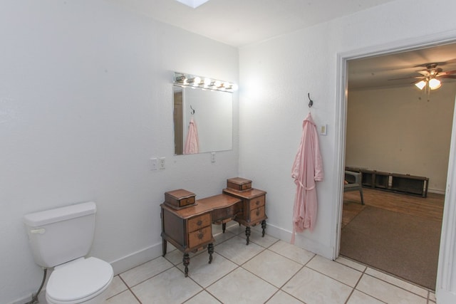 bathroom featuring toilet, tile patterned flooring, ceiling fan, and a skylight