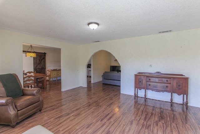 living room with a textured ceiling and dark wood-type flooring