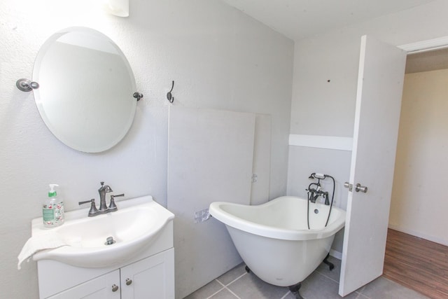 bathroom featuring tile patterned flooring, vanity, and a washtub