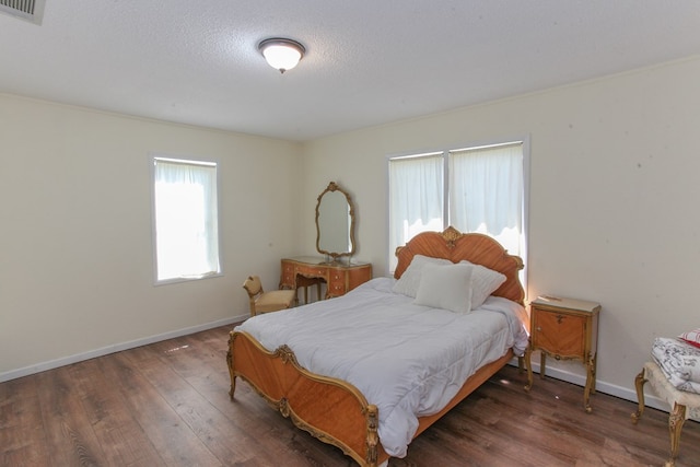 bedroom featuring a textured ceiling and dark hardwood / wood-style flooring