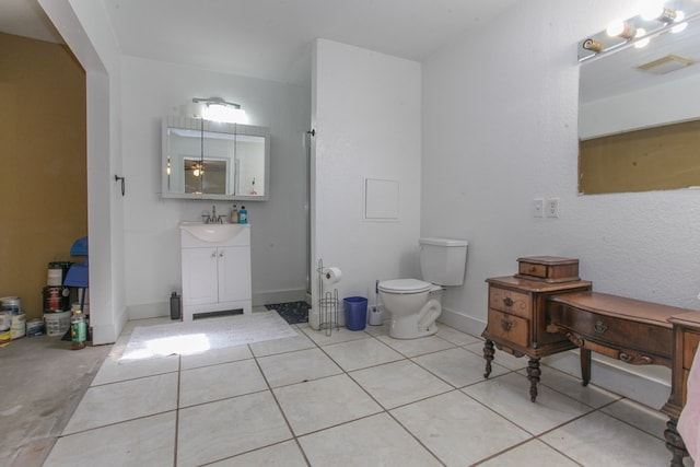 bathroom featuring toilet, vanity, and tile patterned floors