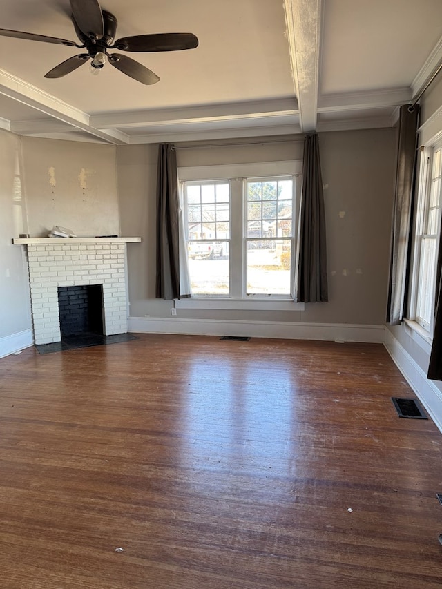 1912 29th St, Snyder, TX 79549 - unfurnished living room with a brick fireplace, dark wood-type flooring, a wealth of natural light, and beam ceiling