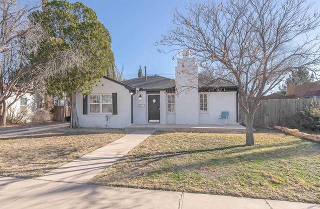 ranch-style home with fence, a front lawn, and brick siding