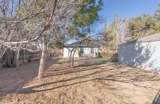 view of yard with fence and an outdoor structure