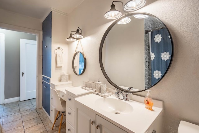 bathroom with toilet, tile patterned flooring, and vanity