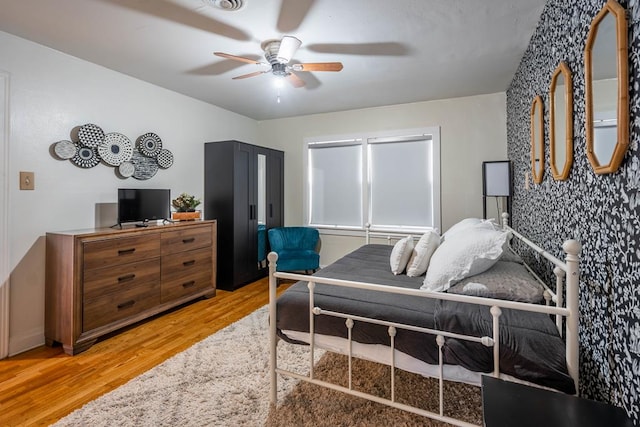 bedroom with a ceiling fan and light wood-style floors