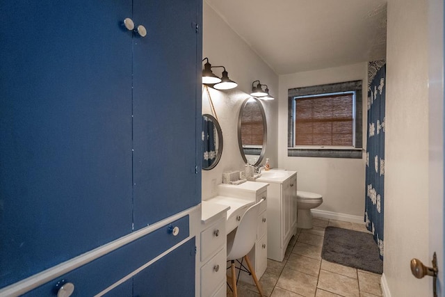 bathroom with toilet, baseboards, vanity, and tile patterned floors