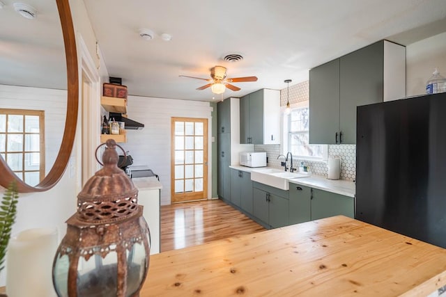 kitchen with white microwave, a sink, visible vents, light countertops, and fridge