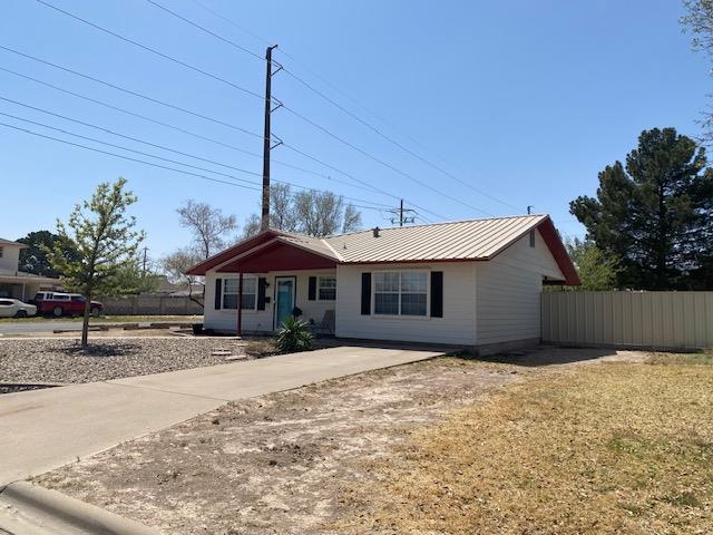 single story home featuring fence and metal roof