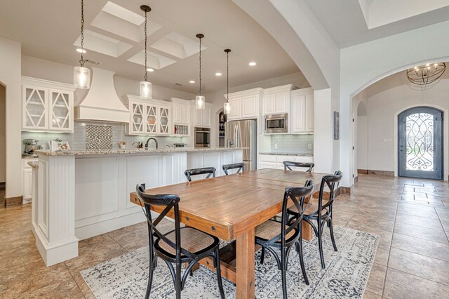 dining area featuring arched walkways, recessed lighting, baseboards, and coffered ceiling