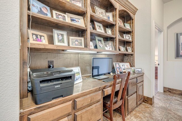 office space with built in study area and light stone finish floors