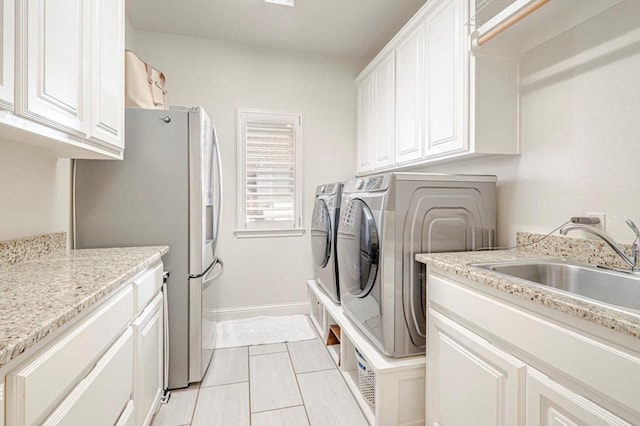 laundry area featuring independent washer and dryer, light tile patterned floors, and baseboards