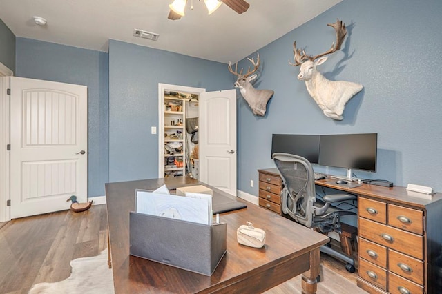 office featuring a ceiling fan, wood finished floors, and baseboards