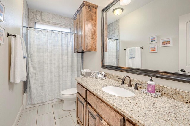 bathroom with toilet, vanity, tile patterned flooring, and shower / tub combo with curtain