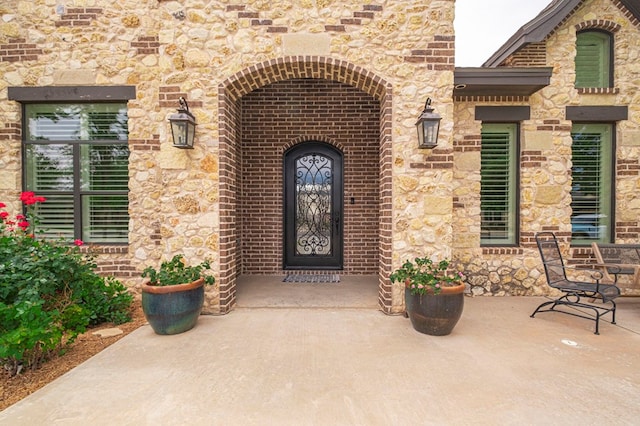 entrance to property featuring stone siding and brick siding