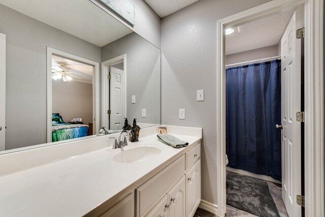 5709 E County Rd 97, Midland, TX 79706 - ensuite bathroom with a textured ceiling, a textured wall, ceiling fan, and vanity