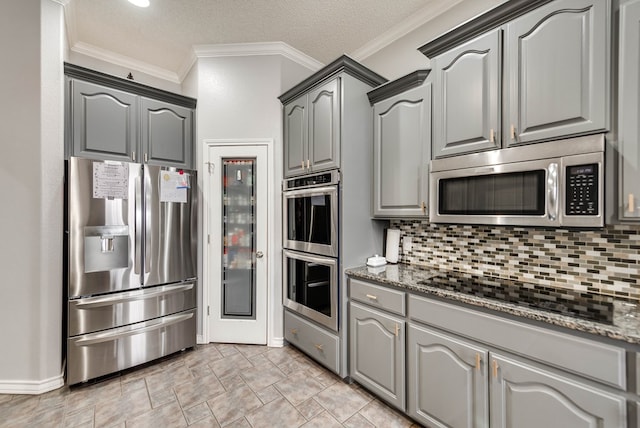 5709 E County Rd 97, Midland, TX 79706 - kitchen with gray cabinets, backsplash, and appliances with stainless steel finishes
