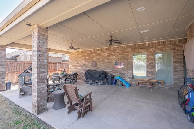 view of patio with fence, outdoor dining space, a ceiling fan, and grilling area