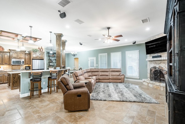 living area featuring stone tile floors, visible vents, and a fireplace