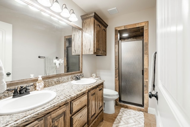 bathroom featuring toilet, visible vents, a shower stall, and a sink
