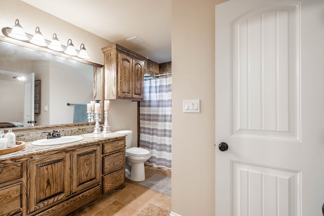 bathroom with toilet, curtained shower, vanity, and stone finish floor