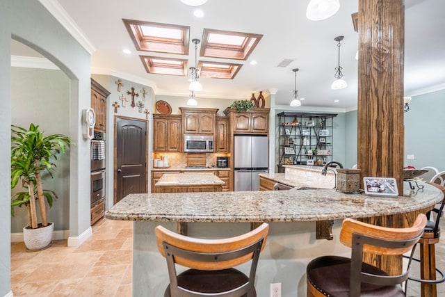 kitchen featuring decorative backsplash, a sink, appliances with stainless steel finishes, a spacious island, and ornamental molding