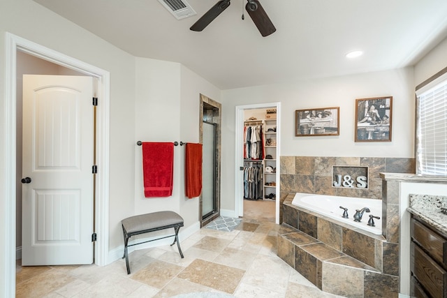 bathroom featuring a shower stall, ceiling fan, a walk in closet, visible vents, and a garden tub
