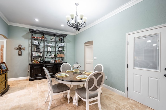 dining area with ornamental molding, stone tile flooring, a notable chandelier, and arched walkways