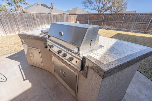 view of patio / terrace with exterior kitchen, a grill, and a fenced backyard