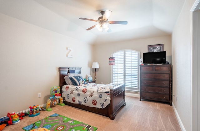 bedroom featuring light colored carpet, a ceiling fan, and baseboards