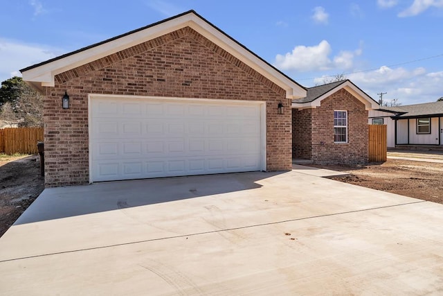 ranch-style house featuring a garage, driveway, brick siding, and fence