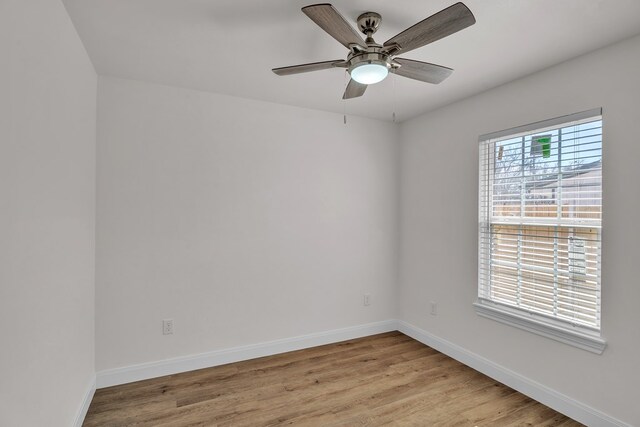 spare room featuring baseboards, ceiling fan, and light wood-style floors