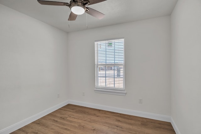 unfurnished room featuring wood finished floors, a ceiling fan, and baseboards