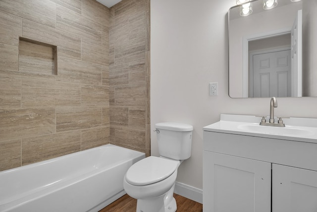 full bathroom featuring baseboards, toilet, wood finished floors, vanity, and shower / washtub combination