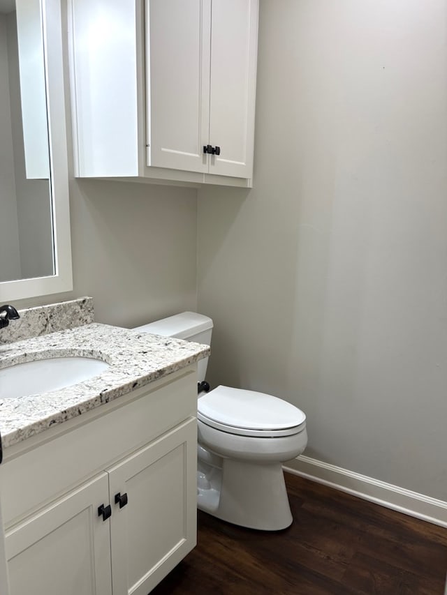 bathroom featuring toilet, vanity, and hardwood / wood-style flooring