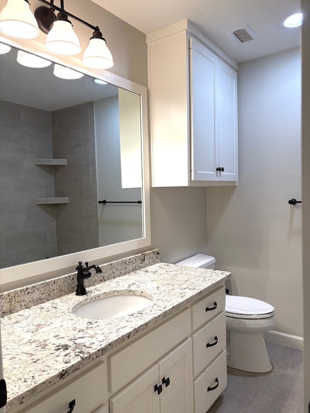 bathroom featuring a shower, wood-type flooring, vanity, and toilet