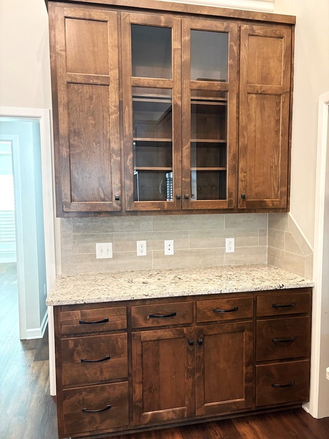 kitchen with decorative backsplash, dark hardwood / wood-style flooring, and light stone countertops