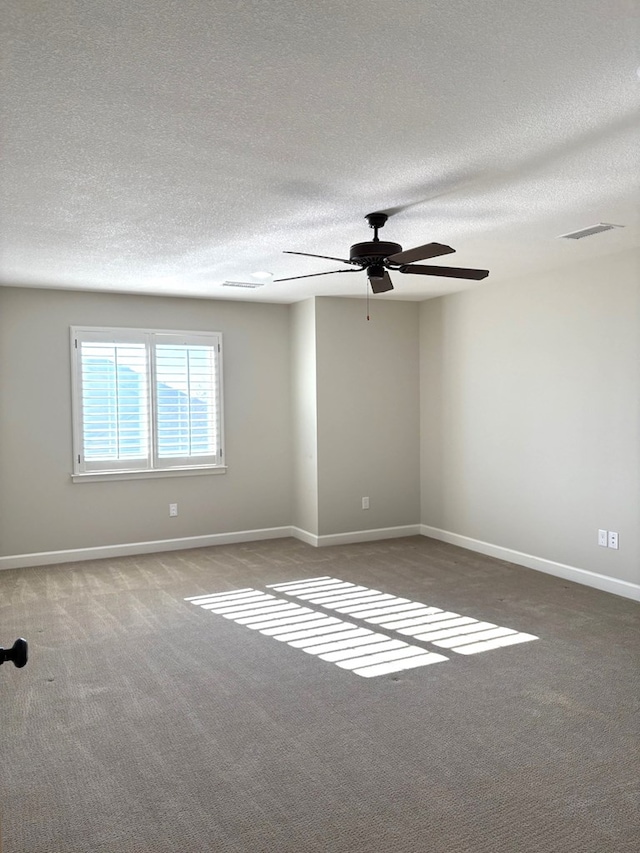 empty room with carpet flooring, a textured ceiling, and ceiling fan