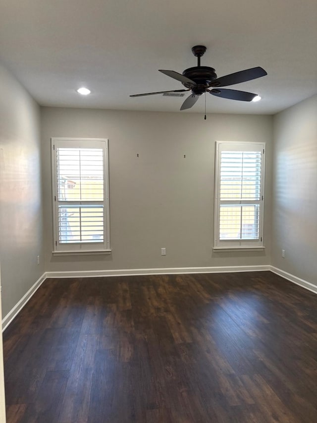 empty room with ceiling fan and dark wood-type flooring