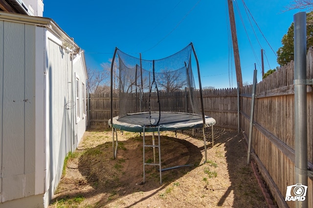 view of yard with a fenced backyard and a trampoline