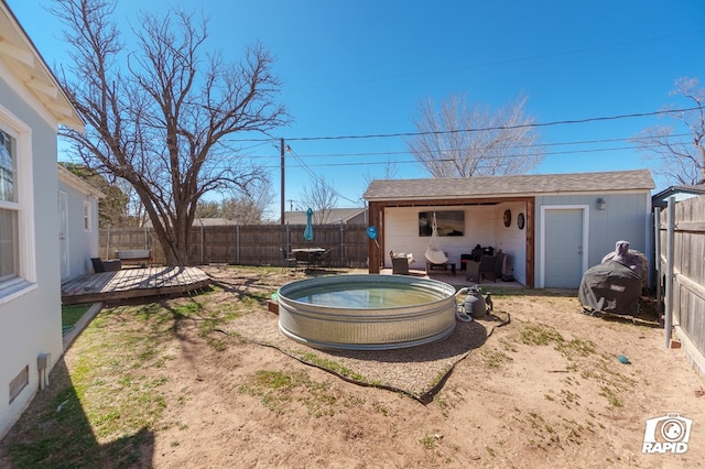 view of yard featuring an outbuilding, a deck, and a fenced backyard