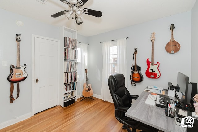 home office with baseboards, ceiling fan, and light wood finished floors