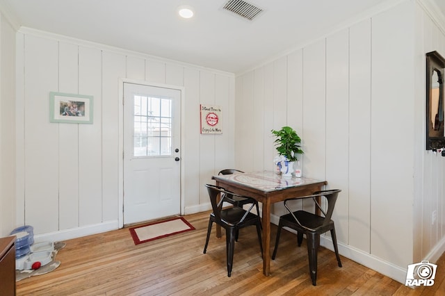 dining area with light wood-type flooring, visible vents, and baseboards