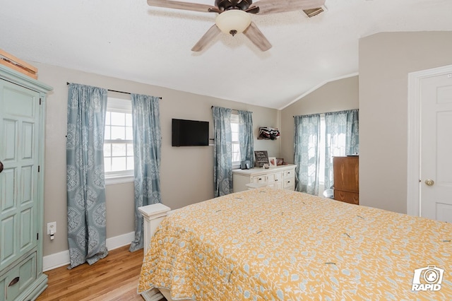 bedroom with lofted ceiling, ceiling fan, light wood-style flooring, visible vents, and baseboards